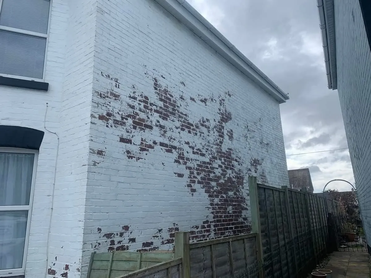 Peeling paint on a brick wall before redecoration in Treverbyn